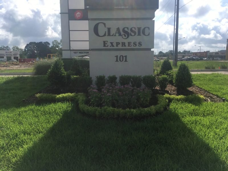 Classic Express 101 sign with a bed of shrubs and pink flowers in front of the lawn